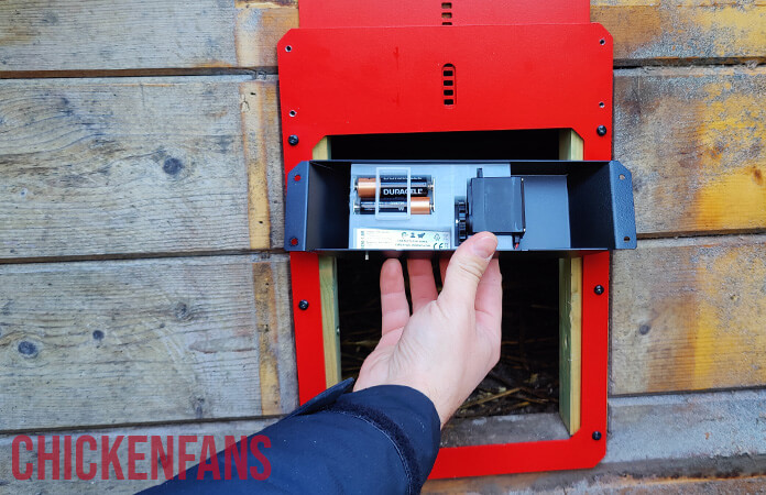 The inside of the door opener of the run chicken coop door, with two AA alkaline batteries