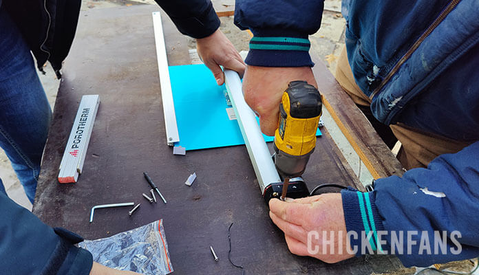 Two persons installing the VEVOR automatic chicken coop ROD