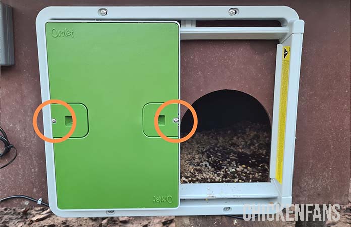 Photo showing which screws to remove to open the Omlet auto door manually