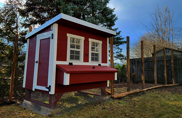 An OverEZ chicken coop that is painted red